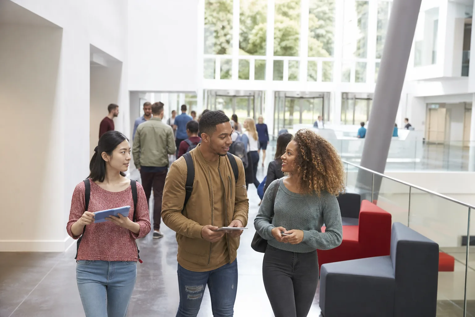 Students walking through a bright school campus hallway