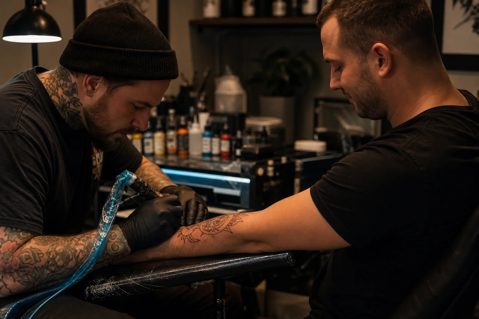 Tattoo artist working on a client's arm in a clean studio